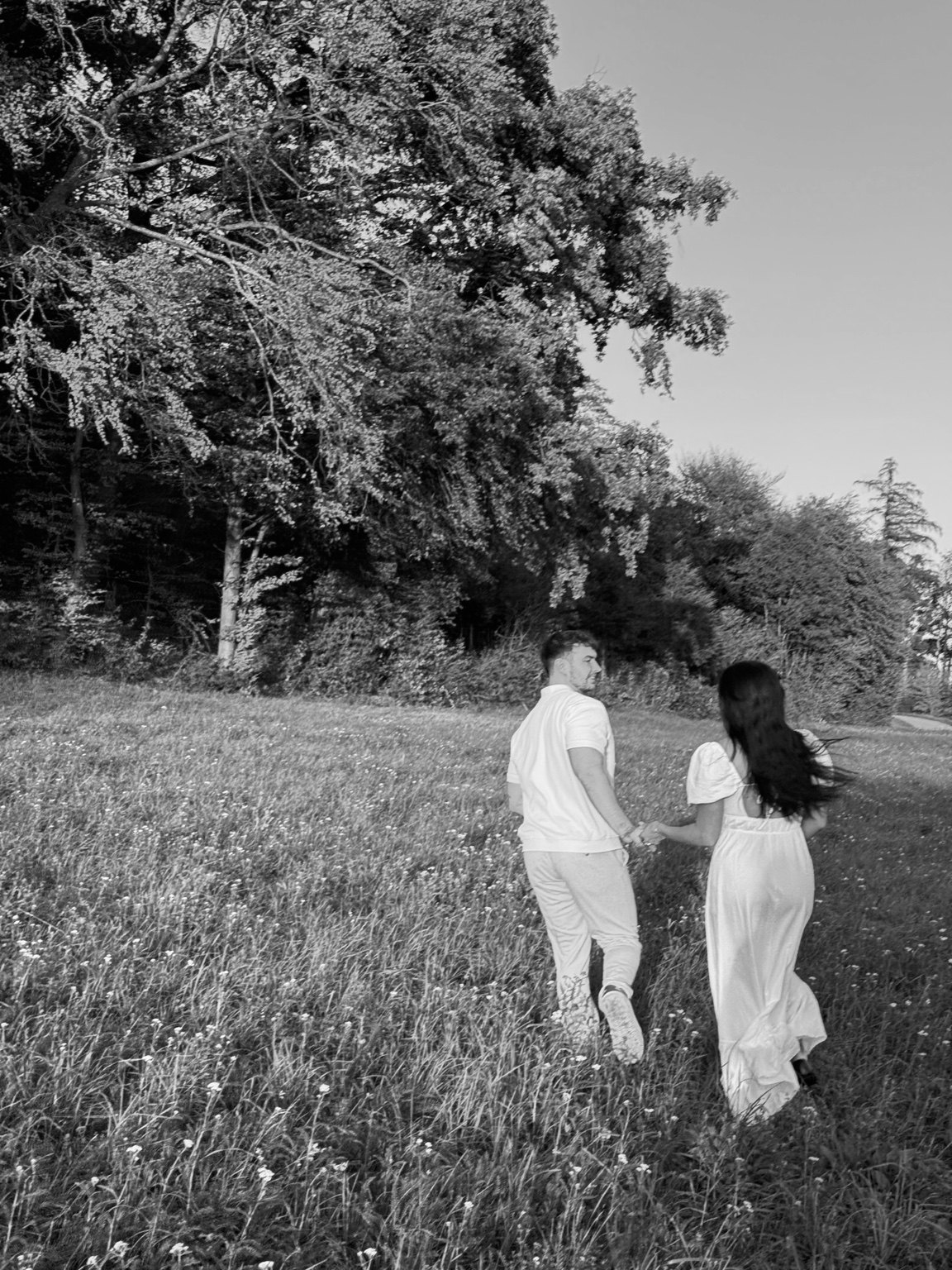 Kira und Jaspar gehen Hand in Hand über die Wiese